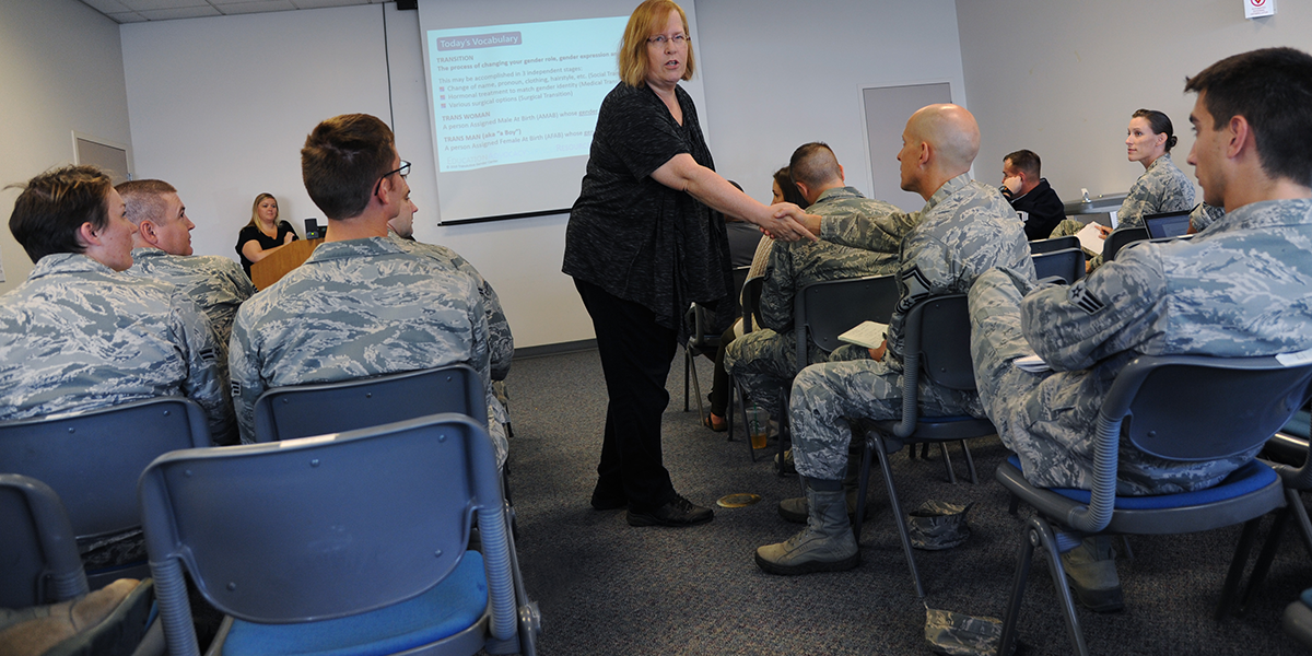Photo of woman shaking soldier's hand in a conference room